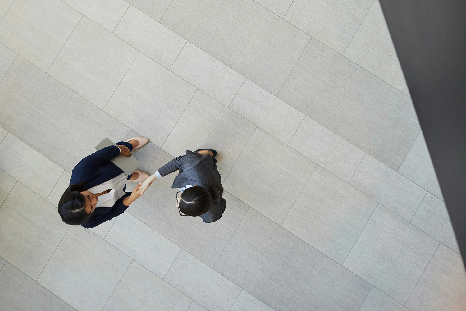 Trust: two people shaking hands in a corporate environment